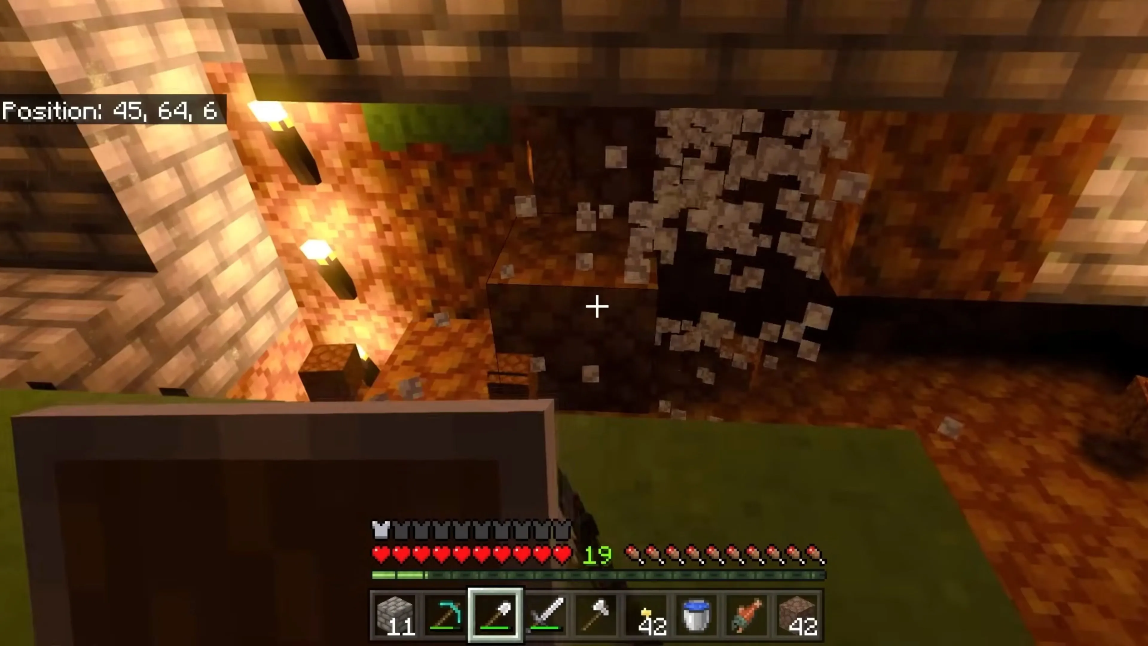 Cảnh quan một ngôi làng nhỏ trong Minecraft vào ban đêm, với những ngôi nhà được thắp sáng bởi ánh đèn, cho thấy yếu tố sinh tồn và cộng đồng.