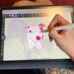 Giao diện ứng dụng Kreska trên iPad với hình minh họa chó màu hồng và bút Apple Pencil đang được sử dụng để vẽ kỹ thuật số.