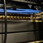 Hệ thống mạng trong phòng lab tại nhà với switch và cáp được sắp xếp gọn gàng, thể hiện việc quản lý hạ tầng mạng hiệu quả.