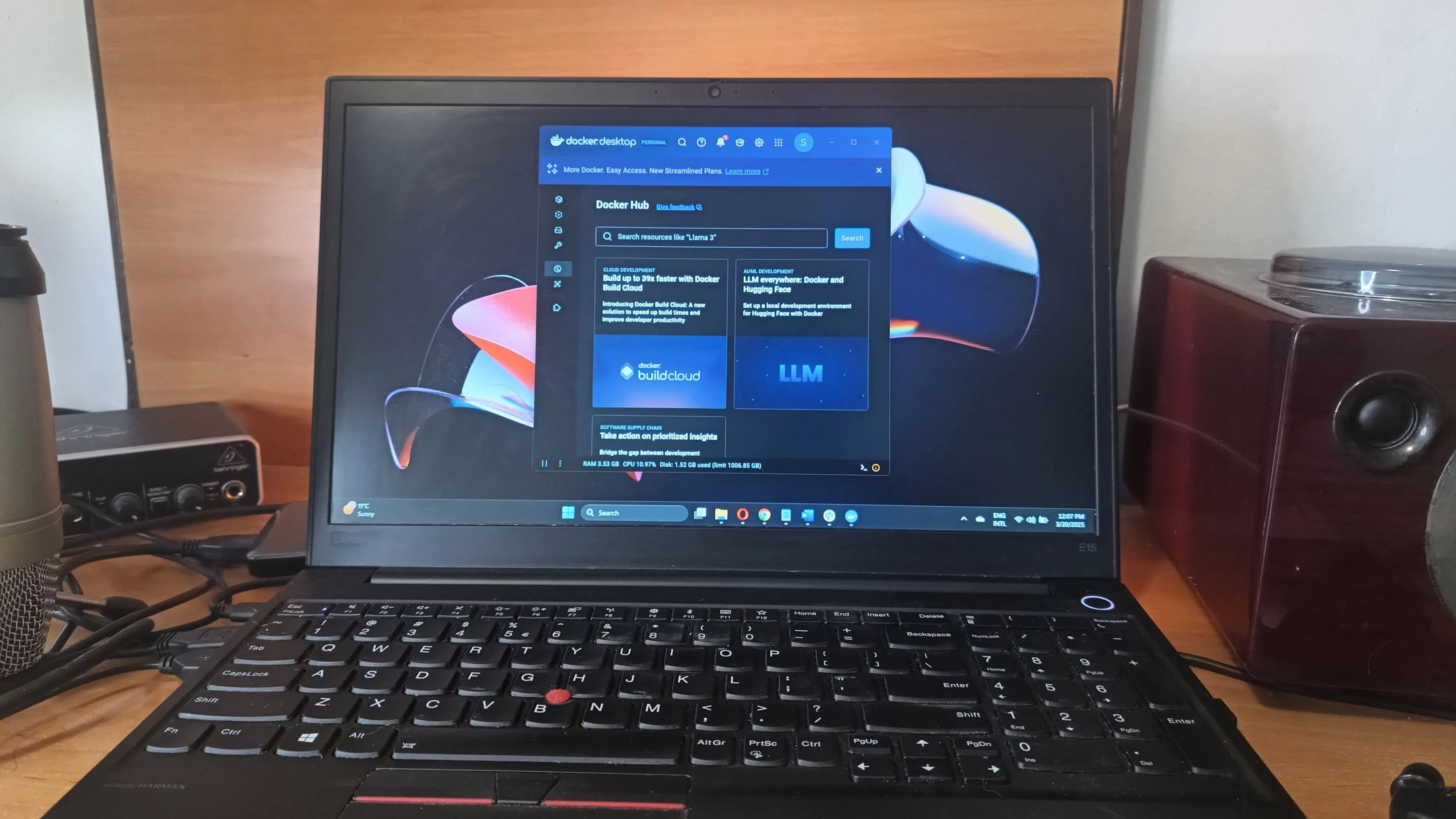 Hình ảnh máy tính xách tay chạy Windows 11 với cửa sổ dòng lệnh hiển thị Docker đang hoạt động, tượng trưng cho khả năng tương thích và chuyển đổi giữa các nền tảng container.