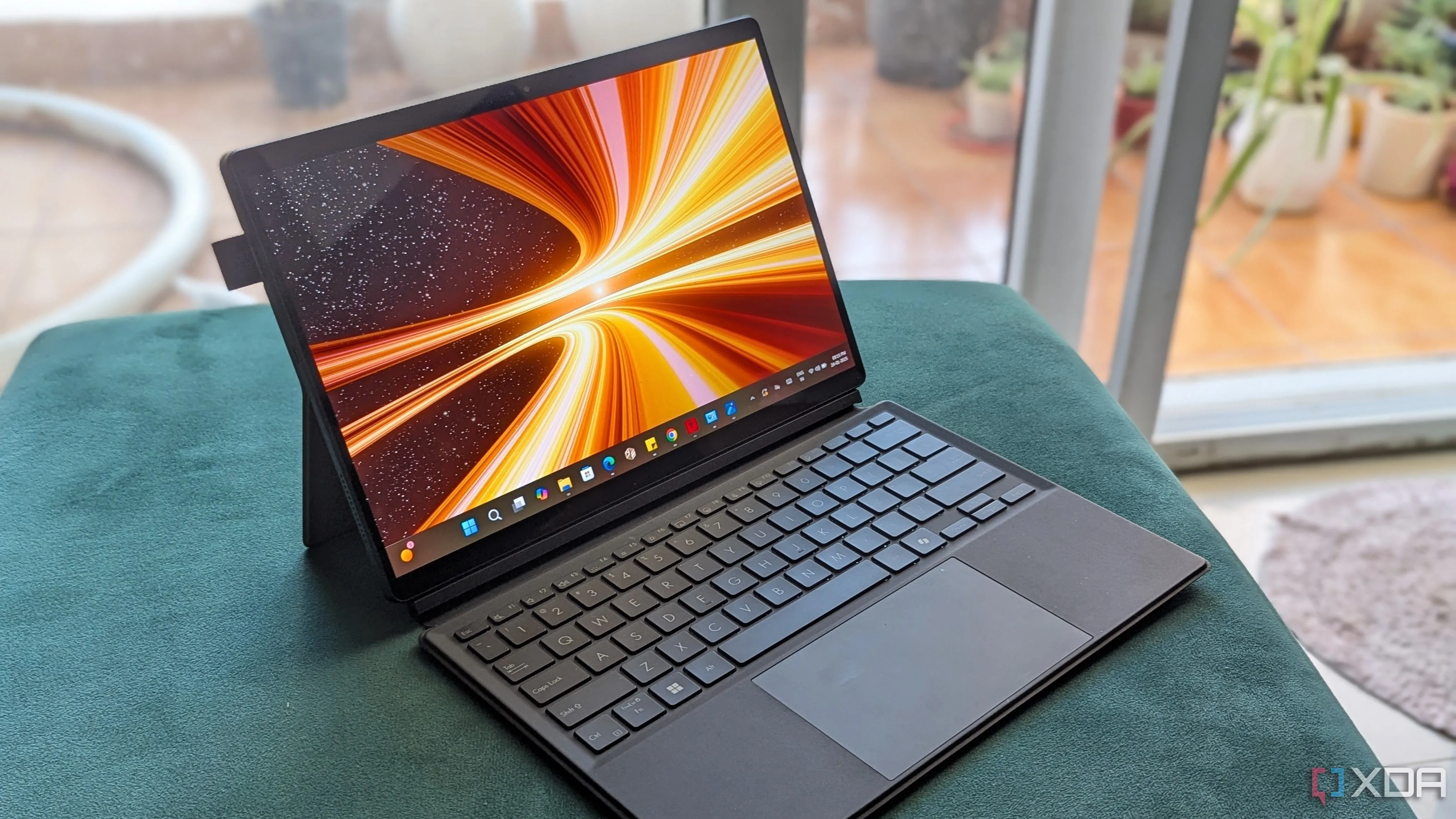 Laptop ASUS ProArt PZ13 ở chế độ lật ngược trên mặt bàn xanh, thể hiện khả năng chuyển đổi linh hoạt giữa laptop và máy tính bảng, lý tưởng cho người dùng sáng tạo.