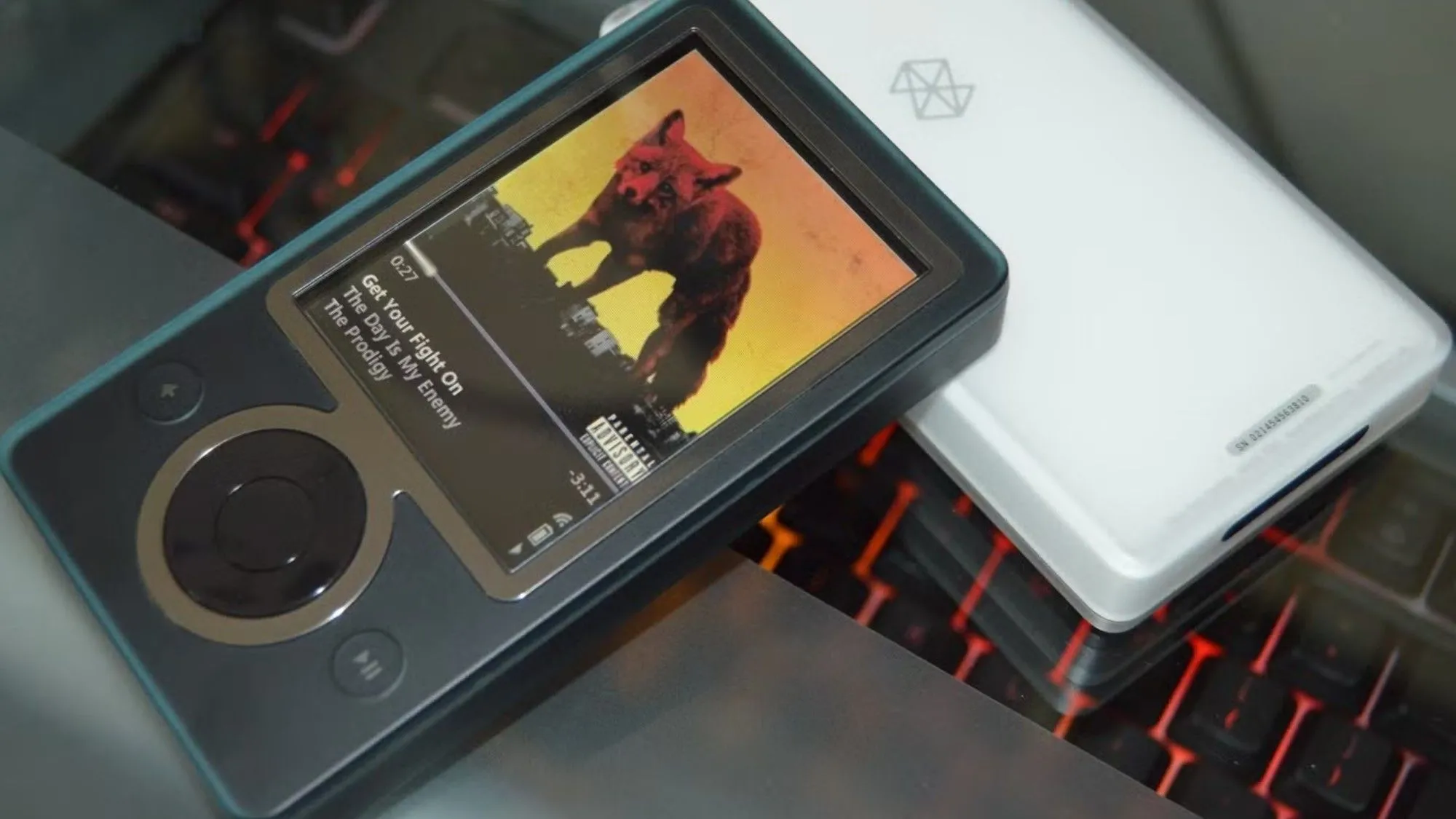 Máy nghe nhạc Zune 30 đang phát nhạc, đại diện cho kỷ nguyên Microsoft chú trọng các thiết bị và dịch vụ tiêu thụ đa phương tiện.