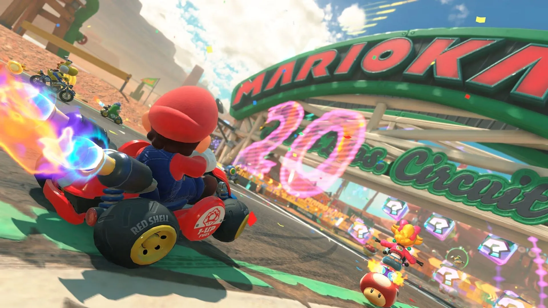 Một cảnh đường đua sôi động với nhiều nhân vật Mario Kart tham gia