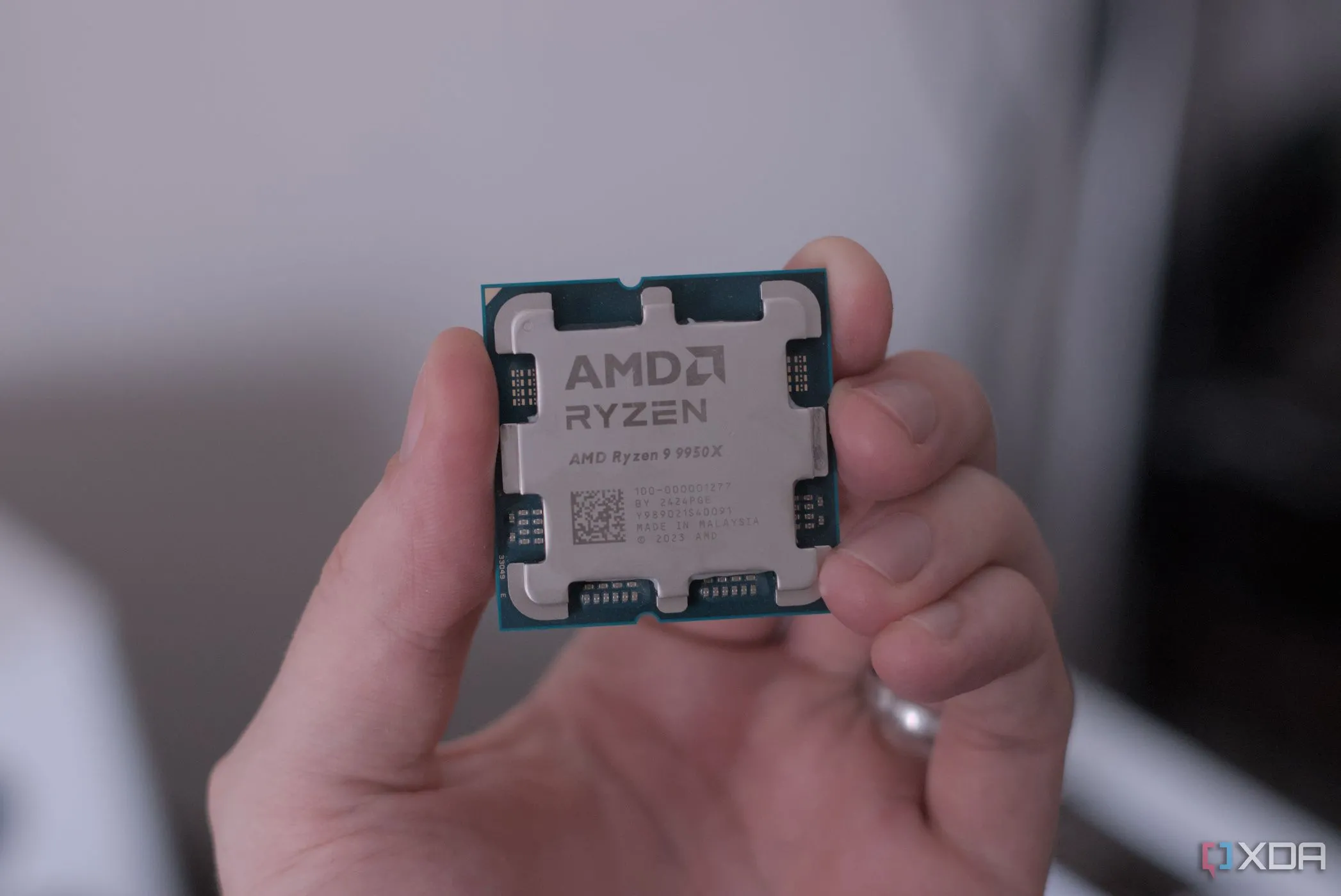 Người dùng đang cầm bộ vi xử lý AMD Ryzen 9 9950X, minh họa việc undervolt CPU để tối ưu hiệu năng và nhiệt độ.