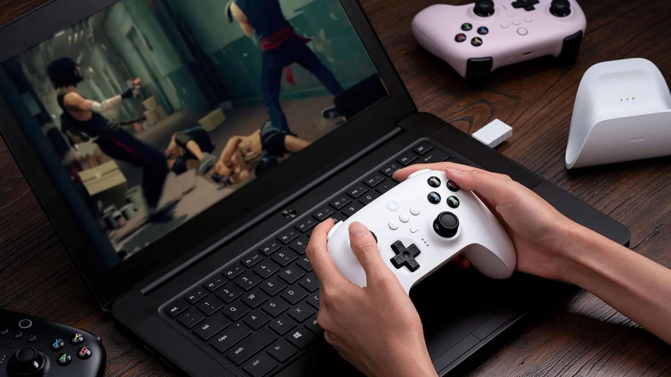 Người dùng đang chơi game trên laptop với tay cầm 8BitDo Ultimate Wireless