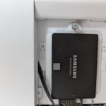Ổ cứng SSD Samsung 860 EVO 250GB màu đen được lắp đặt trên vỏ máy tính màu trắng, minh họa sự nhỏ gọn và hiệu quả năng lượng của SATA SSD cho home server.