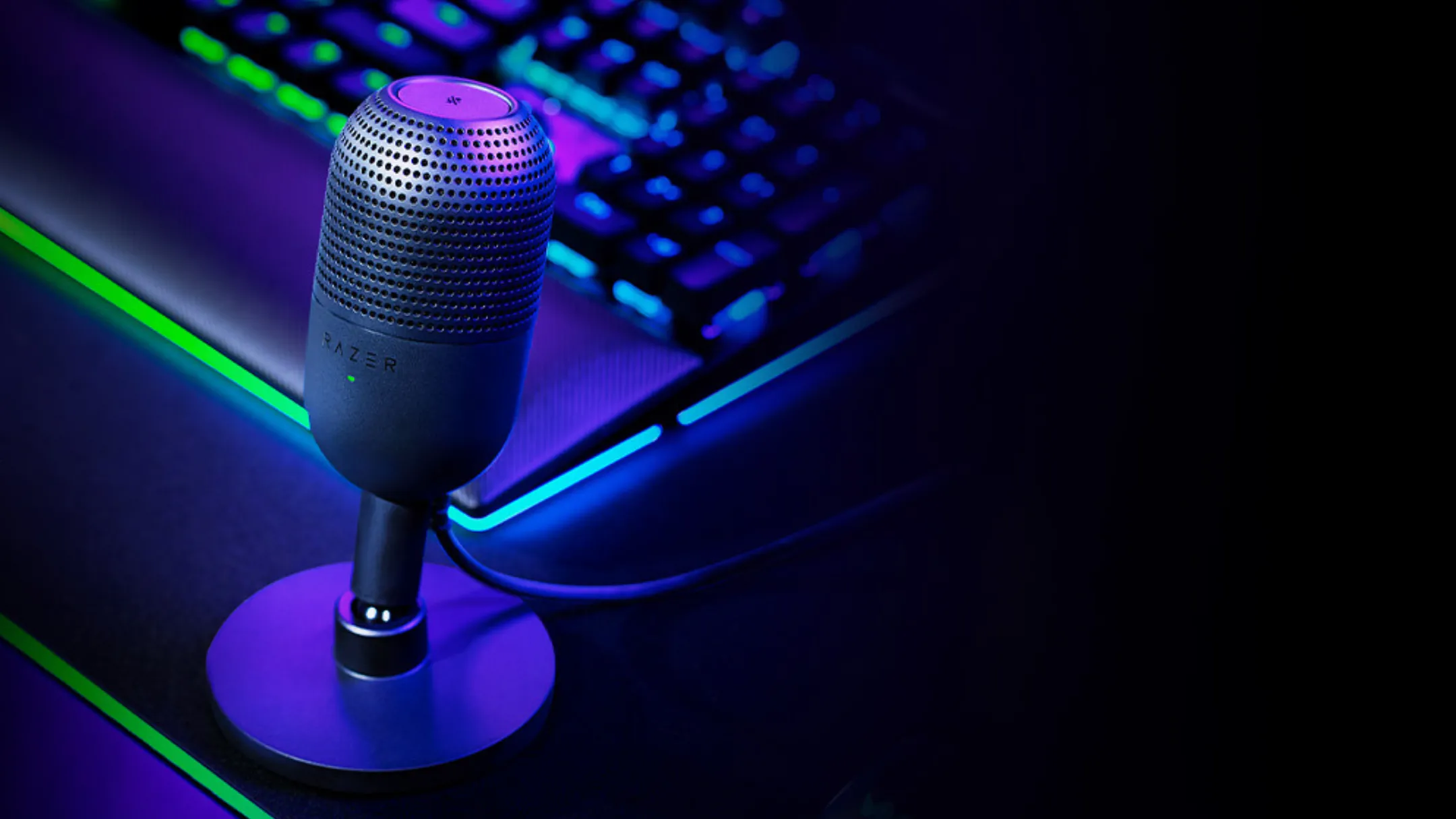 Razer Seiren V3 Mini đặt trên bàn làm việc cạnh bàn phím cơ