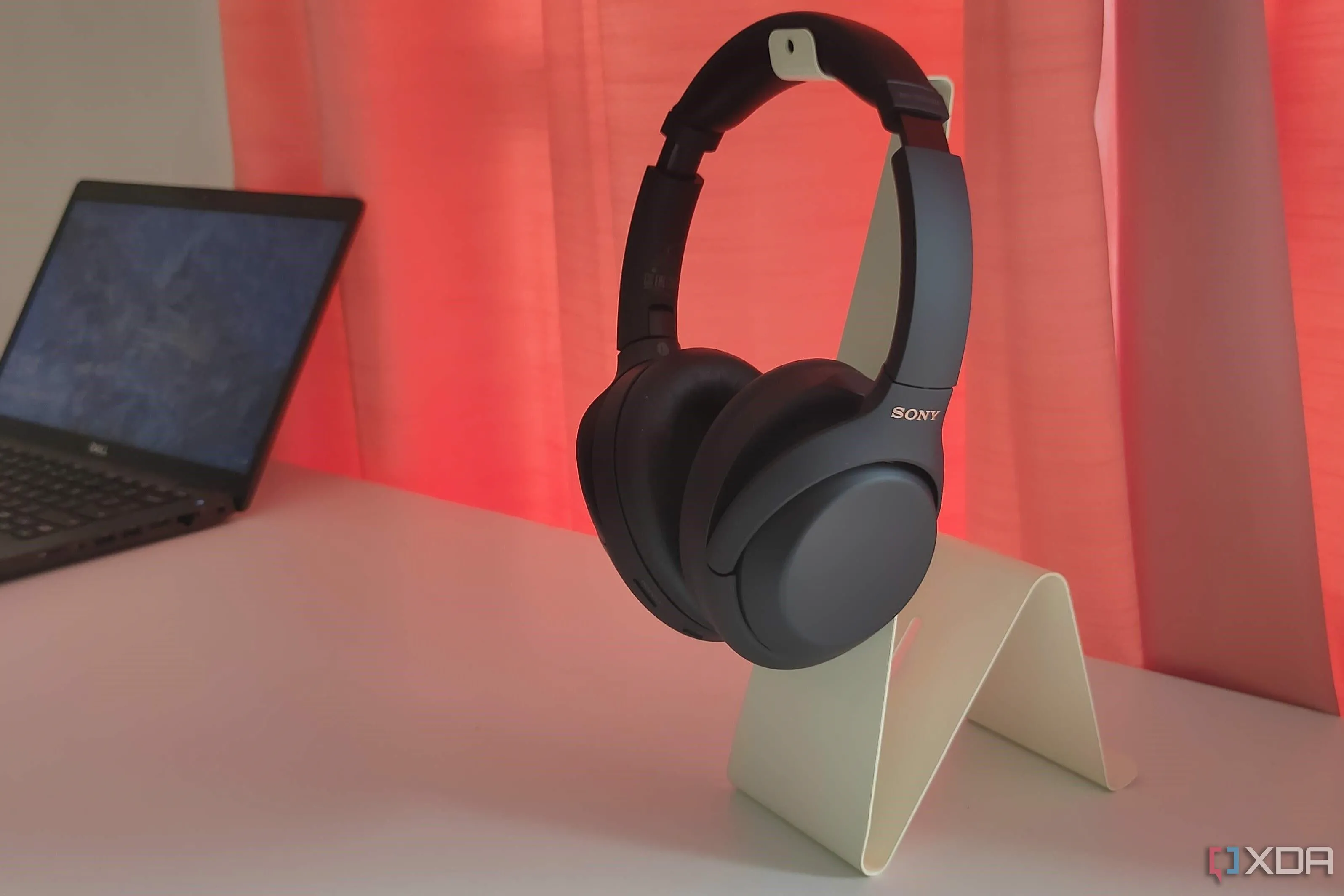 Tai nghe chống ồn Sony WH-1000XM4 màu đen đặt trên giá đỡ màu trắng