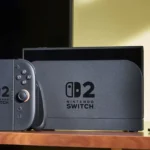 Thẻ game Nintendo Switch 2 màu đỏ và hệ máy console đặt trên bàn